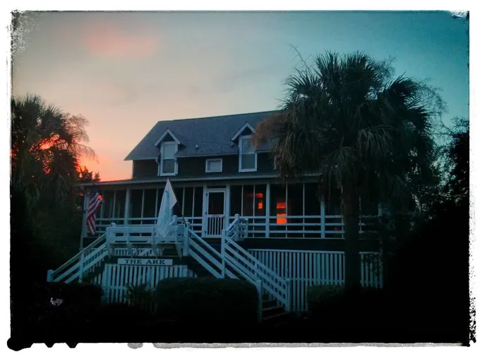 The Ark, a raised island house with a screened porch at dusk on Sullivan's Island